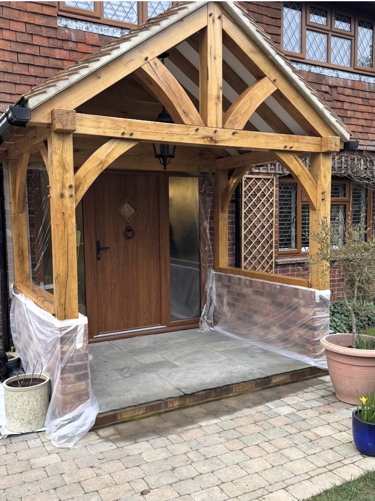 Restored oak porch with hand-cut curved braces and golden honey finish, Copthorne
