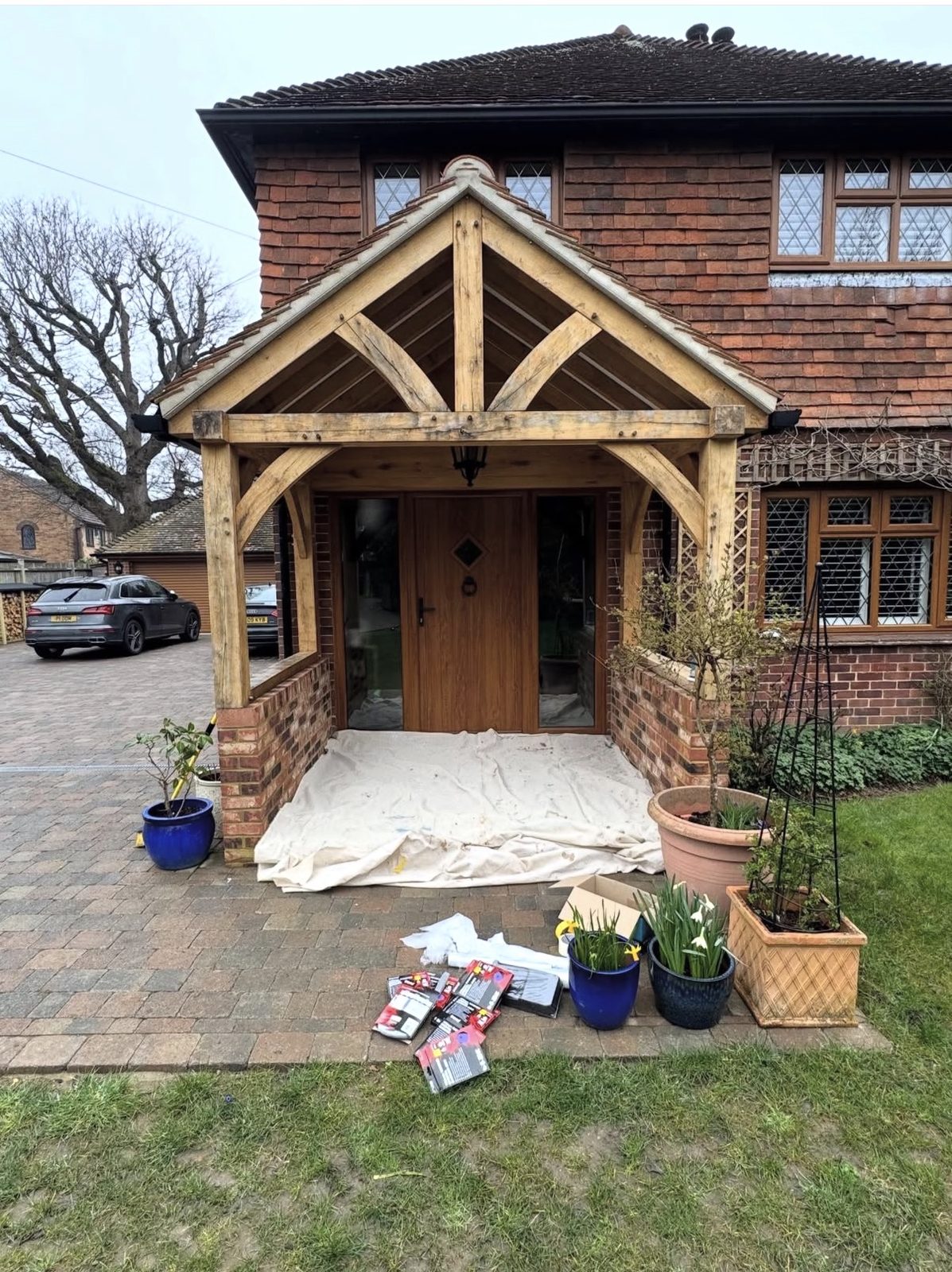 Wider view of the finished oak porch in its setting, showing the front of the house